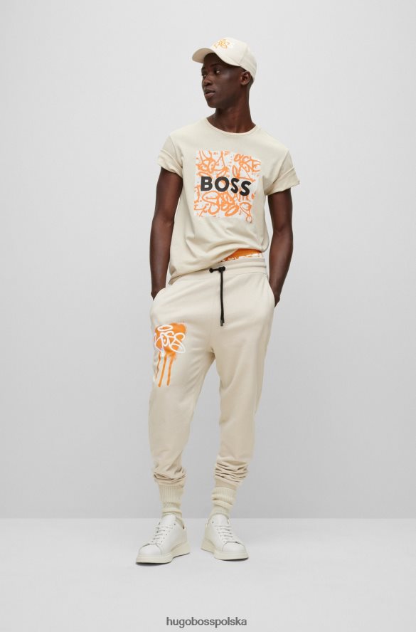 Hugo Boss Hugo jasnobeżowe spodnie dresowe o swobodnym kroju z grafiką graffiti jasny beż R0X0H61905