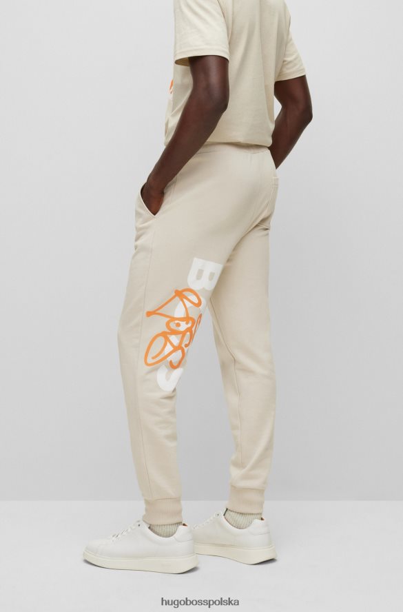Hugo Boss Hugo jasnobeżowe spodnie dresowe o swobodnym kroju z grafiką graffiti jasny beż R0X0H61905