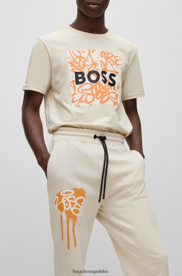 Hugo Boss Hugo jasnobeżowe spodnie dresowe o swobodnym kroju z grafiką graffiti jasny beż R0X0H61905