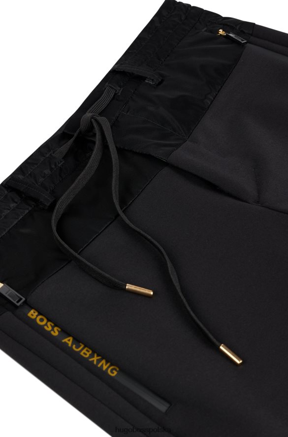 Hugo Boss x ajbxng Wąskie spodnie z regularnym stanem i wspólnym brandingiem czarny R0X0H62728